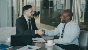 Two businessmen shaking hands after successfully finalizing a bridging loan agreement.