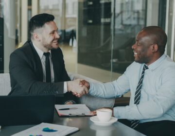 Two businessmen shaking hands after successfully finalizing a bridging loan agreement.