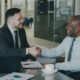 Two businessmen shaking hands after successfully finalizing a bridging loan agreement.