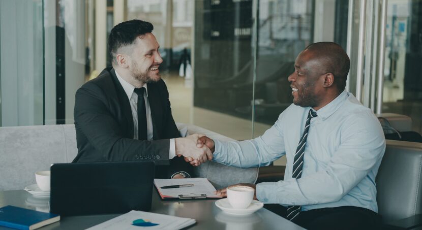 Two businessmen shaking hands after successfully finalizing a bridging loan agreement.